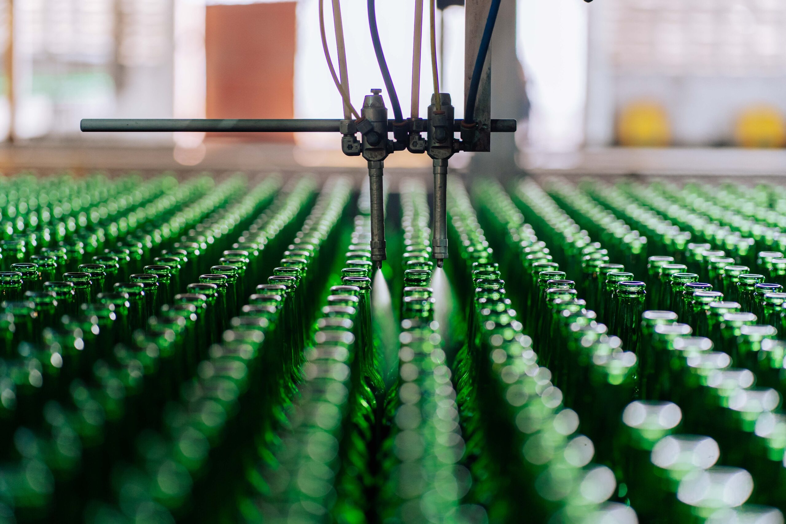 Glass bottles on an automated line in a factory, showcasing industrial glass making.